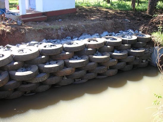 Proteção de margem e ancoradouro feito por muro de pneus amarrados com arame e preenchidos com rachão de pedra